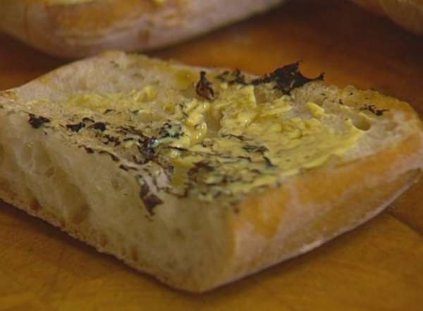 Чиабатту разрезать на 4 части, затем каждый кусок пополам вдоль. Прогреть на сковороде, где жарились котлеты, сбрызнуть обжаренную сторону хлеба оливковым маслом, смазать горчицей. 