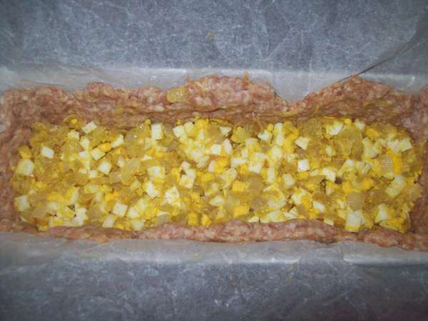 В мясной фарш добавить 2 яйца, посолить и поперчить по вкусу. Хорошо вмешать. Выложить 2/3 фарша в форму для запекания и сформировать дно и бортики (в форму я предварительно выложила бумагу для выпечки). Выложить в рулет начинку и равномерно закрыть оставшимся фаршем.