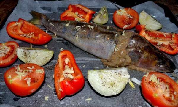 Наполняем голову и шкурку готовым фаршем,смазываем маслом и выкладываем на противень(я на пергамент),добавить порезанный помидор,лук,красн.болг.перец-посыпать солью,чёрным молотым перцем.
