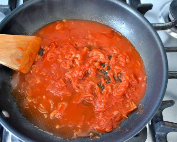 Добавить томатный концентрат и разбавить его несколькими ложками воды от приготовления пасты. Потушить все пару минут и снять сковороду с огня. 