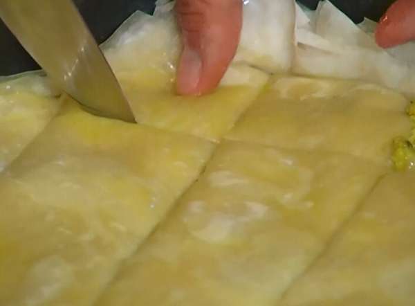 Верхний слой смазать маслом и ножом разрезать пахлаву на ромбики.