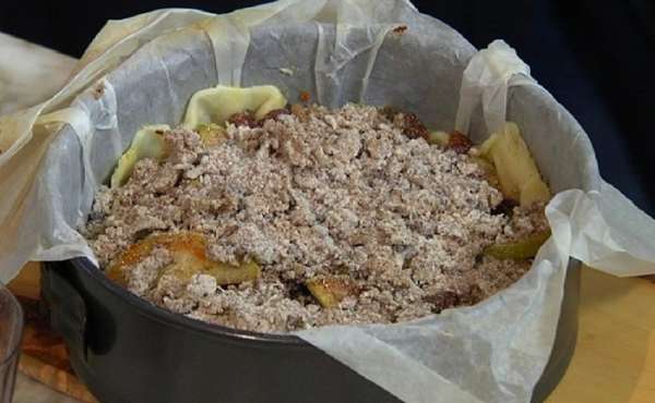Вынуть песочный корж из духовки, удалить горох с бумагой, равномерно разложить фрукты с изюмом и посыпать сверху засыпкой. Вынуть песочный корж из духовки, удалить горох с бумагой, равномерно разложить фрукты с изюмом и посыпать сверху засыпкой.