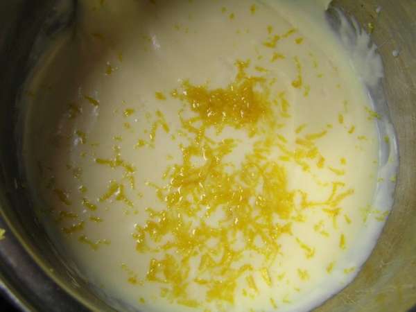 Для лимонного крема с миндалем соединить оставшееся сгущеное молоко со сливочным маслом, добавить цедру и сок лимона,