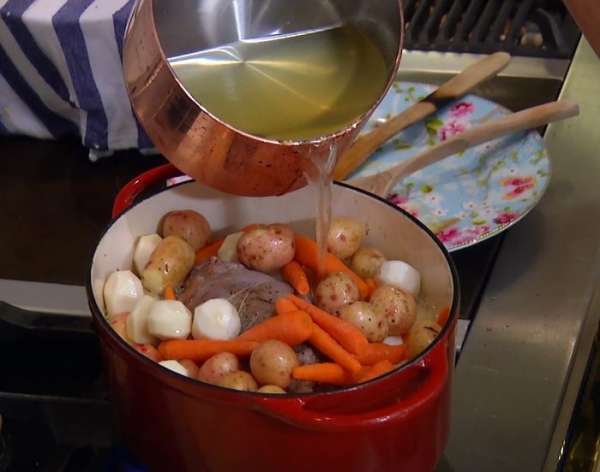 Вернуть мясо в кастрюлю, влить апельсиновый сок, добавить картофель, морковь и репу, влить сидр и овощной бульон, так чтобы мясо с овощами были покрыты жидкостью.