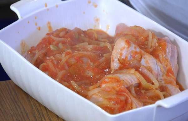 Курицу разрезать на четыре части, выложить в жаропрочную керамическую форму и полить сверху соусом.