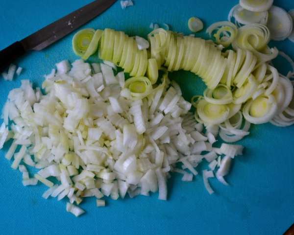 Репчатый лук очистить и нарезать помельче. Лук порей (светлую часть) нарезать тонкими кольцами. Репчатый лук очистить и нарезать помельче. Лук порей (светлую часть) нарезать тонкими кольцами.