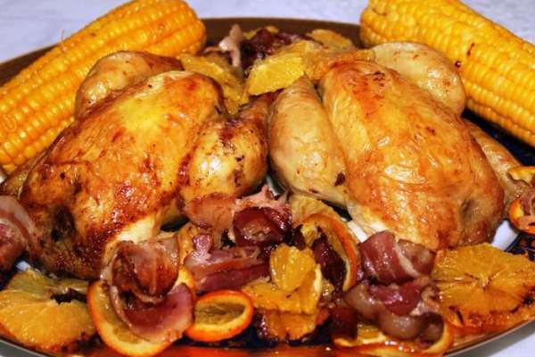 Подать цыплят можно с вареной кукурузой и не забудьте выложить поджаренные ароматные кусочки бекона и апельсинов. 
