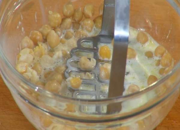 Нут вынуть из молока шумовкой и слегка размять толкушкой.