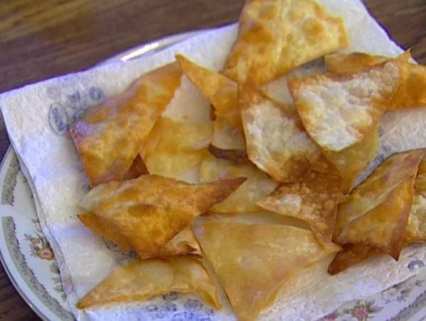 Разогреть в глубокой сковороде растительное масло, опускать в него кусочки лаваша и обжаривать, пока не получатся чипсы. Выложить на бумажное полотенце, чтобы избавиться от лишнего масла.