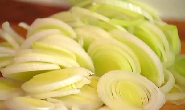 Светлую часть лука-порея нарезать кольцами.