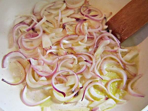 Лук нарезать полукольцами и слегка обжарить на оливковом масле.