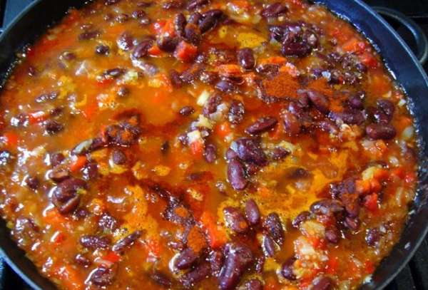Затем добавить в сковороду помидоры, паприку и фасоль. Я взяла томатный продукт от Tomato Gusto, в нем – только свежие томаты, соль, лавровый лист и семена укропа.
Прогреть смесь на сковороде.
