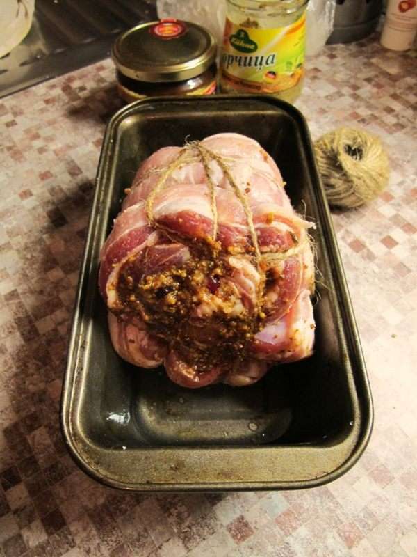 Свернем мясо рулетом и перевяжем бечевкой. 
В посуду для запекания наливаем на дно немного воды и отправляем мясо в духовку на час при температуре 170-180°С. Периодически поливаем кусок, выделившимся соком.
Если мясо сильно зарумянивается прикрываем его сверху листом фольги.
Затем допекаем еще минут 30-40, доливая воду по необходимости.