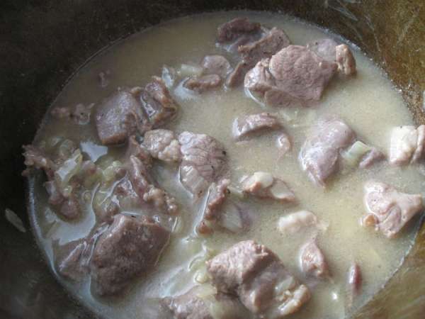 К луку добавить мясо, перемешать (огонь не уменьшать). Мешать часто, раз в 2 – 3 минуты. Накрыть плотно крышкой.