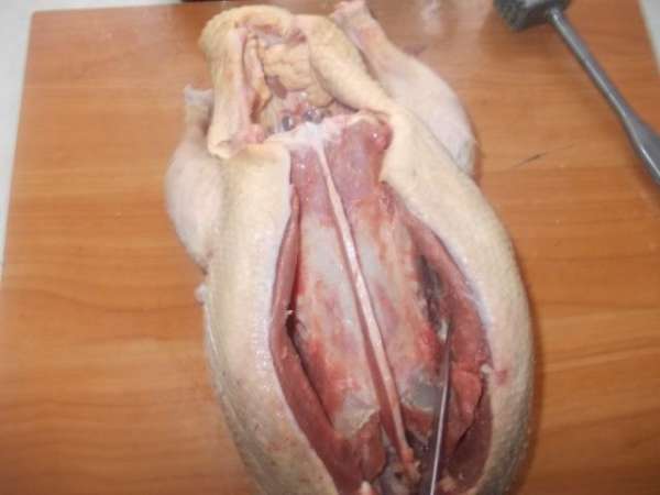 Разрезаем утку вдоль грудки,стараясь оставлять каркас без мяса. Нужен очень острый нож.