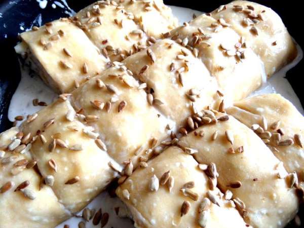 Смазываем молоком и присыпаем снова семечками.