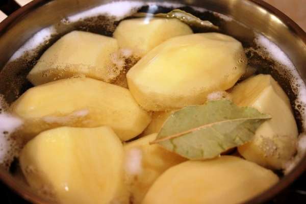 Пока запекается мясо можно приготовить гарнир – пюре с пикантным вкусом. Для этого нужно очистить картофель и отварить его, добавив соль и лавровый лист.