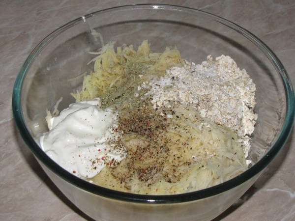 Картофель натереть на мелкой терке (я измельчила на кухонном комбайне), добавить овсяные хлопья, сметану, чеснок, пропущенный через пресс, посолить, поерчить по вкусу. Хорошо перемешать.