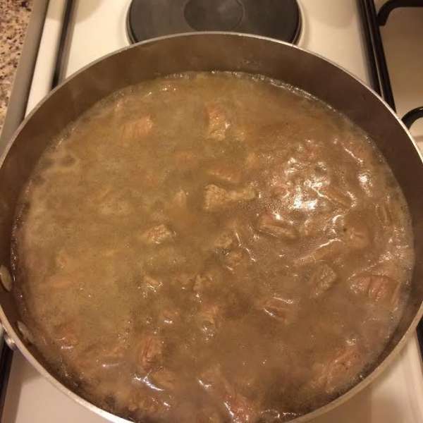 Залить горячей водой (вода слегка должна покрывать мясо) и тушить до готовности.