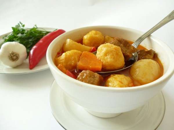 Добавляем к мясу с уже почти готовым картофелем томатную заправку и затем клецки,тушим еще 10 минут с приоткрытой крышкой,клецки должны всплыть.Затем выключить огонь и дать блюду настояться еще минут 10-15.Все,можно приступать к трапезе.По желанию в тарелку с гуляшом можно добавить нарезанную зелень,добавить еще чесночка.Приятного вам аппетита!
