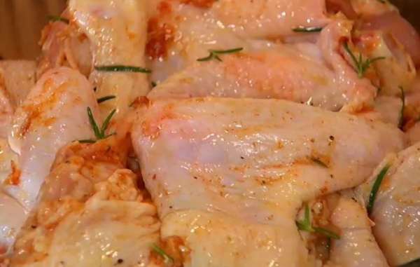 Выложить куриное мясо в глубокую посуду, смазать со всех сторон маринадом и оставить на 30 минут.