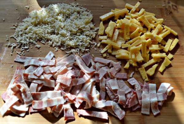 Тем временем порезать полосками бекон, сыр-гауда порезать брусочками, а пармезан натереть на мелкой тёрке.
