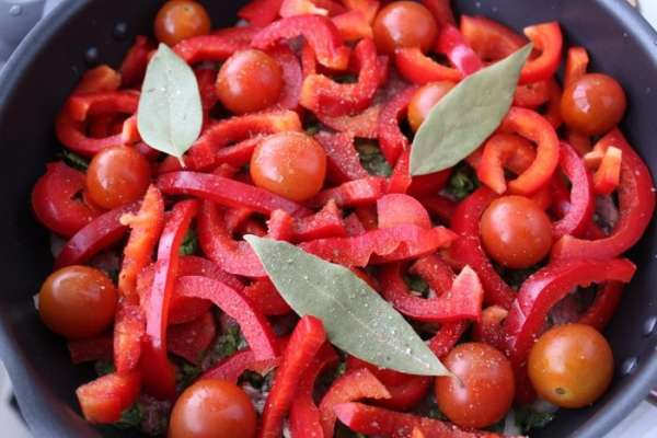 Приправить специями, добавить лавровый лист и залить бульоном. Мясо должно быть полностью покрытым. Довести до кипения, закрыть крышкой и томить на слабом огне 1,5 часа. 
