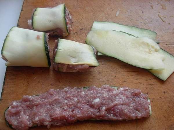 Режем кабачок длинными тонкими полосками (у меня получились полоски размером 5 см. на 15 см. ).
На полоску кабачка, выкладываем фарш, сворачиваем рулетом.