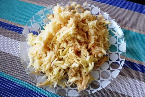 Яблоки (3-4 шт.) почистим от шкурки и семенной коробочки и натрем на крупной терке. Затем добавим в них клюкву и аккуратно перемешаем. Клюква у меня замороженная, размораживать ее не надо!