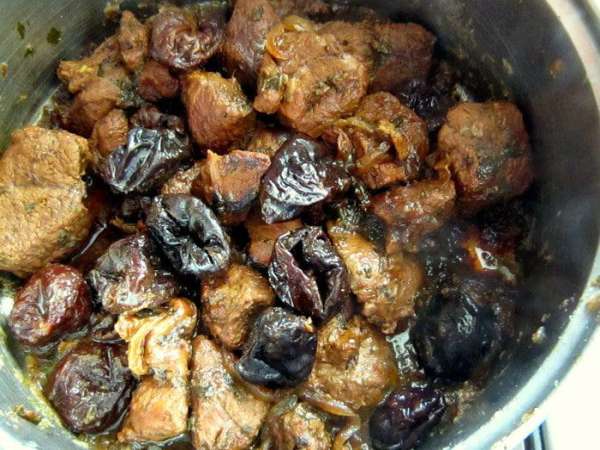 Снять кастрюлю с огня. Добавить чернослив, перемешать, накрыть крышкой и оставить на 15 мин.