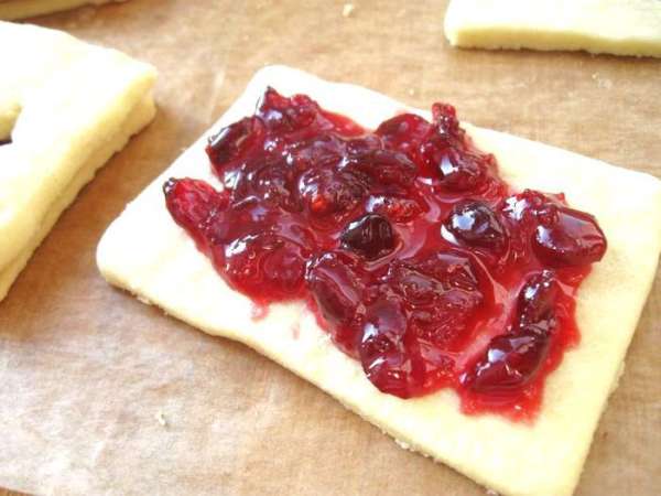 На целые половинки нанести слой начинки (черничное и клюквенное варенье) и накрыть оставшимися печеньями с вырезанной серединкой. На целые половинки нанести слой начинки (черничное и клюквенное варенье) и накрыть оставшимися печеньями с вырезанной серединкой.