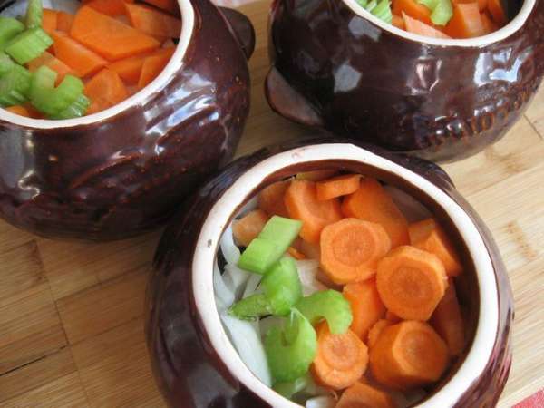Мясо порезать кусочками, посолить, поперчить, добавить сухой тимьян, перемешать и  положить пропорционально в горшочки. У меня их было 3 шт. Стебель сельдерея помыть, почистить от волокон, порезать на кусочки. Морковь, лук почистить. Морковь порезать кружочками, лук полукольцами. Добавить в горшочки. Залить горячей водой, чтобы она на  2/3 прикрывала содержимое горшочка. 