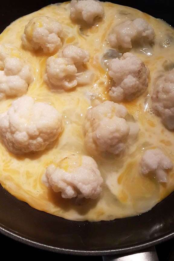 Затем взболтать яйца с молоком и солью. Выложить капусту на сковороду, слегка политую маслом. Вылить омлет. И несколько раз быстро все перемешать, пока яйцо не схватится.