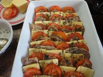 5. Форму для выпечки смазать растительным маслом и выложить мясо, перекладывая сыром и помидорами.
6. Приготовить заливку: смешать 1 си. ложку оливкового масла, сок половины лимона, базилик, кориандр, оставшийся перец и соль. Залить заправкой мясо.
духовку включить для разогрева до 200 градусов.