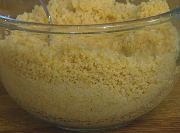 Запаренный кускус перемешать, сбрызнуть лимонным соком, 1 ст. ложкой оливкового масла, посолить, поперчить, перемешать и дать кускусу немного постоять.