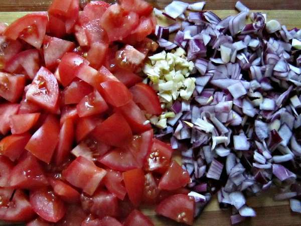 Нарезать небольшими кусочками помидоры, мелко порезать лук, чеснок.