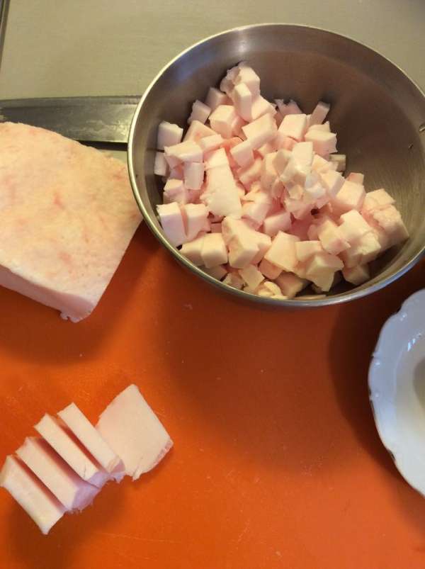 Одновременно нарезаем сало кусочками как на салат Оливье и выпаливаем на сковороде. Дополнительно нарезаем сало прямоугольными кусочками. После того, как сало вытопилось на этом жире жарим свинину. После добавляем сметану в сковороду. Получается достаточно жирная подлива. 