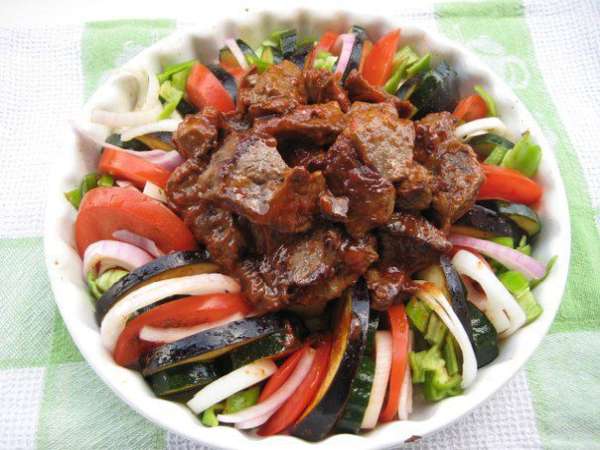 Достать форму, в центр выложить мясо, посыпать чесноком, на дно формы налить вино, продолжить запекание еще 20 минут (до готовности овощей)