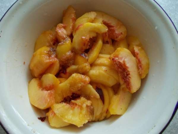 Очищаем персики от кожуры. Делим  пополам, а потом режем дольками.