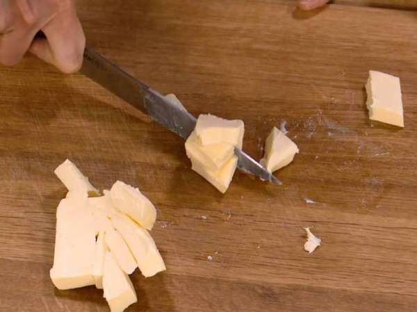 Предварительно охлажденное сливочное масло нарезать небольшими кусочками. Предварительно охлажденное сливочное масло нарезать небольшими кусочками.