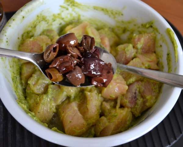 Добавить к кусочкам курицы песто, яичный белок и столовую ложку оливок (лучше всего сорта taggiasche - они обладают более ярким вкусом). Перемешать все.