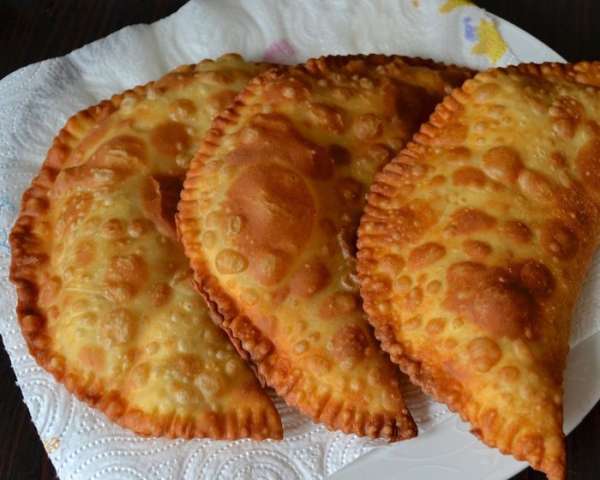 Готовые чебуреки сложить на впитывающую бумагу (бумажное полотенце).