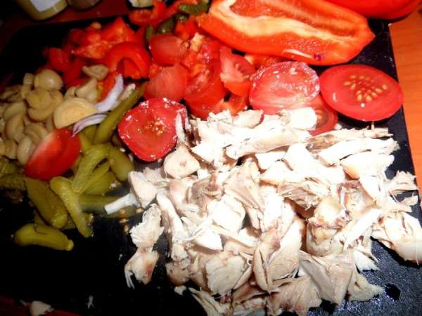 Отварную куриную грудку потрошим на волокна и разрежем на кусочки.