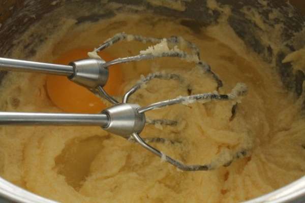 Все продукты должны быть комнатной температуры, поэтому надо заранее достать их из холодильника. Сливочное масло растереть с сахаром на малых оборотах миксера. По одному добавить яйца.