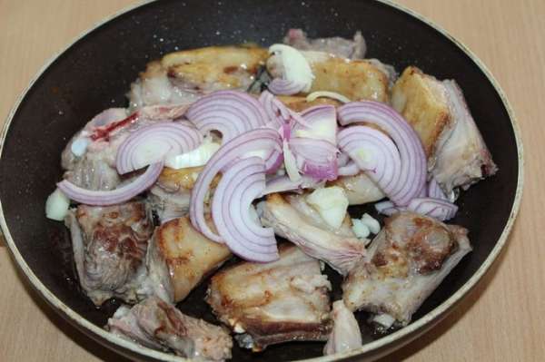 Добавить нарезанные лук и чеснок, потушить вместе с мясом до мягкости лука, посолить, поперчить.