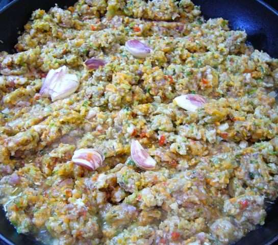Разогреть сковороду, влить в нее оливковое масло. Как только масло нагреется, отправить в сковороду фарш. Даем немного ингредиентам «сговориться», периодически помешивая. Раздавить 4 неочищенных зубчика чеснока, отправить на сковороду к фаршу.