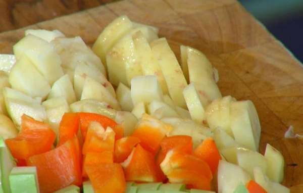 Картофель почистить, порезать маленькими кубиками, выложить в сковороду с луком и чесноком, все слегка посолить.
