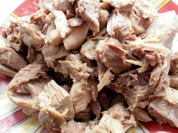 Мясо отварить. С мяса снять кожицу, нарезать довольно крупными кусочками (благодаря черному перцу и лавровому лису, у меня оно получилось очень ароматным! Запах очень напоминал куриную тушенку). Сладкий перец помыть, почистить и нарезать небольшими кубиками. Очистить лук и чеснок. Лук нарезать тонкими полукольцами, а чеснок - как можно мельче. 