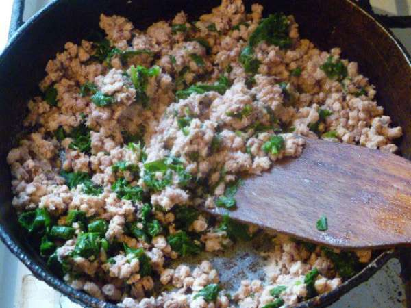 Вареное мясо измельчить. Я перекручиваю на мясорубке.
На сковороде разогреть растительное масло, добавить шпинат и мясо, слегка прогреть вместе.