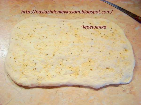 Посыпаем ¼ смеси кунжута и бадьяна (аниса) и пальчиками вдавливаем ее в тесто…